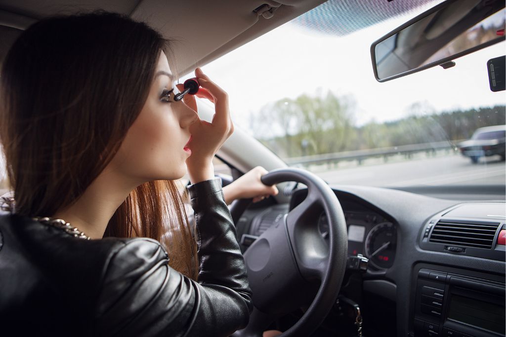 woman doing makeup while driving in the car