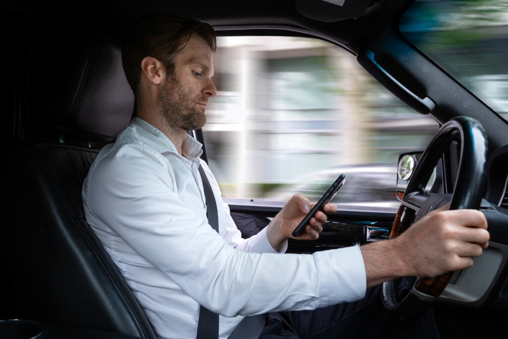 man texting while driving