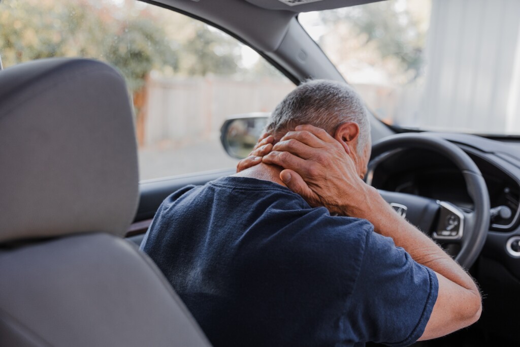 man holding his neck after a car accident