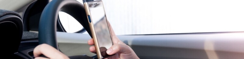 A person using their cell phone while driving.